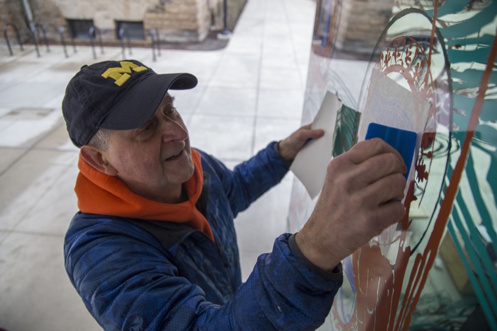 Jim Cosgwell applying vinyl for 'Cosmogonic Tattoos.'