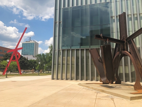 A sculpture made of brown steel in the shape of a swing
